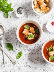 Cold tomato soup gazpacho with croutons and Basil on a light background. Vegetarian food, top view