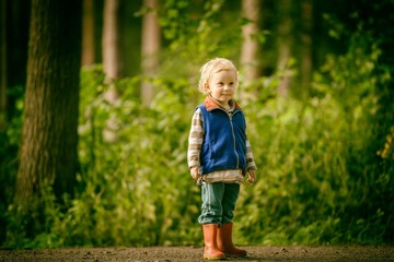 Little caucasian boy playing outdoor in summer.