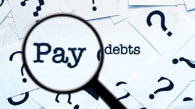 Magnifying glass on pay off debt 