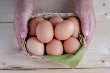 hand holding egg on wooden background