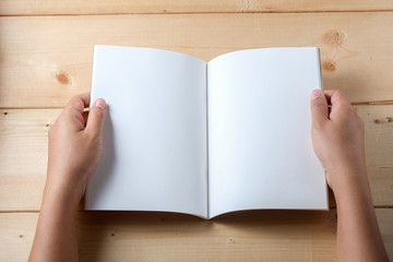 Obraz premium Hands hold book on wood table