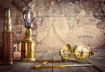 Ship lamp, compass, divider and spyglass on the wood table. Travel and nautical theme grunge background. Retro style. - obrazy, fototapety, plakaty