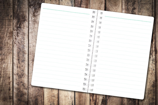 Open notebook paper with line on wood background for design with copy space for text or image.