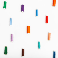 several spools of sewing thread on white