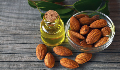 Almonds seed and almond oil on old wooden background for beauty spa and treatment.Selective focus.
