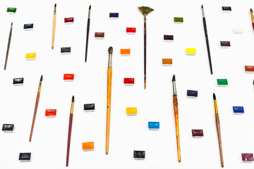 side view of many paint brushes and watercolors