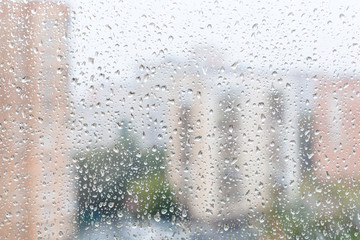 view of raindrops on window glass of urban house
