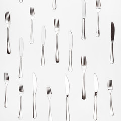 table knives and forks arranged on white