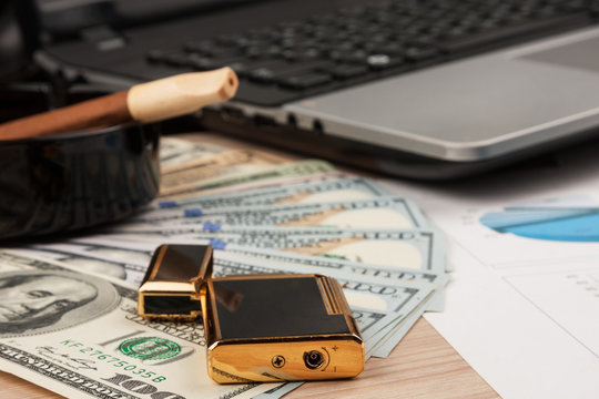 Working businessman desk, Lighter and laptop, cigar and money