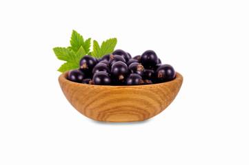 black currant in a wooden bowl isolated on white background.