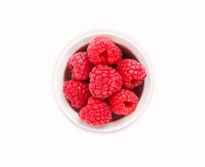 Raspberries in a white ceramic bowl isolated on white background