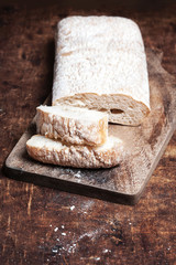 Fresh bread on wooden background. White baked bread on a wooden