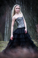 Portrait of beautiful girl in black dress in nature