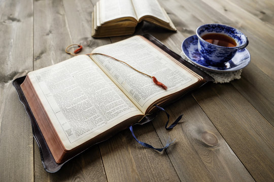 Bibles and cup of tea on wood table. Non TM Bibles.