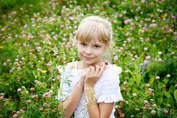 Portrait of beautiful little girl in white dress on the nature