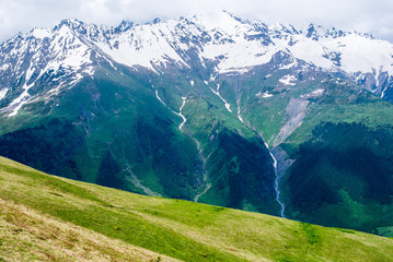 Mountain landscape with grassland in the foreground. On a trek from Mestia to Mazeri (Becho). Georgia. The Caucasus