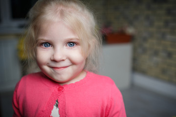 Portrait of a beautiful little girl with flowers on background of brick wall