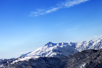 Fototapeta na wymiar Snowy mountains and blue sky in early sunny morning