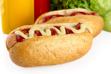 Hot dogs with ketchup with lettuce in the background