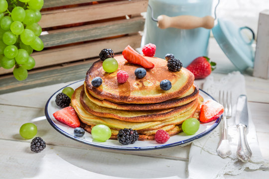 Tasty pancakes with maple syrup and fruits