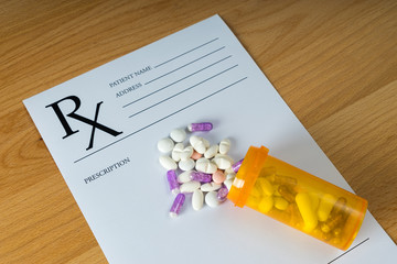 Medicine Pills on Prescription Form on wooden background. © klenger