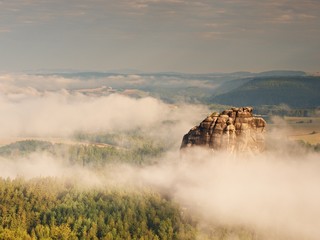 Misty valley, sharp rocks gentle cut creamy fog to strips. Long gulch