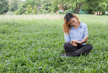 Fototapeta premium Woman holding a book in meadows on the sunshine of morning.