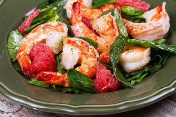 Shrimp, grapefruit and spinach salad in green plate