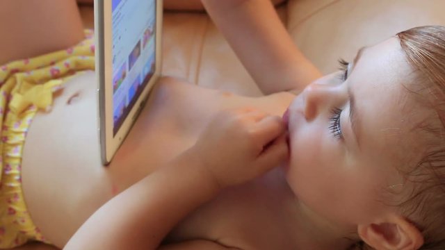 clouse-up portrait small child on the tablet looks cartoon. Full HD. 1920x1080