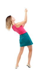 back view of standing girl pulling a rope from the top or cling to something. girl  watching. Rear view people collection.  backside view of person.  Isolated over white background. Blonde in a red