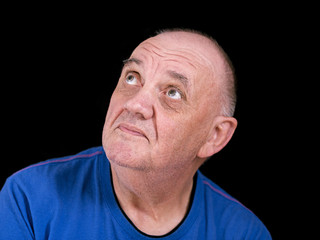 portrait homme âgé regardant pardessus épaule sur fond noir