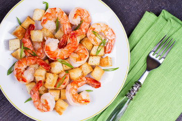 Shrimp with crispy croutons and scallions. View from above, top studio shot