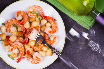 Shrimp with crispy croutons and scallions. White wine bottle. View from above, top studio shot