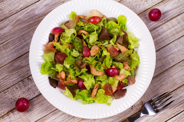Chicken and red grape salad in white plate. View from above, top studio shot