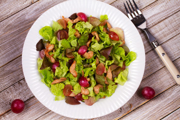 Chicken and red grape salad in white plate. View from above, top studio shot