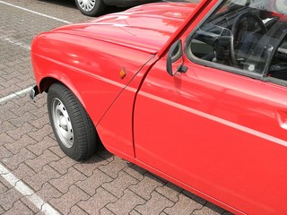 Karosserieflanke eines frisch lackierten roten französischen Kleinwagen mit fünf Türen der...