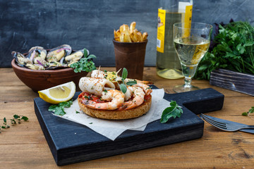 bruschetta with shrimps on rustic kitchen board