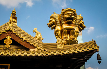 Fototapeta na wymiar Details of roof golden Lions on Buddhist Jing An Tranquility Temple - Shanghai, China