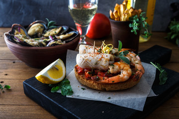 Appetizer with spicy tomato squids and shrimps on toast