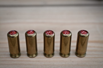five gas bullets on the wooden table