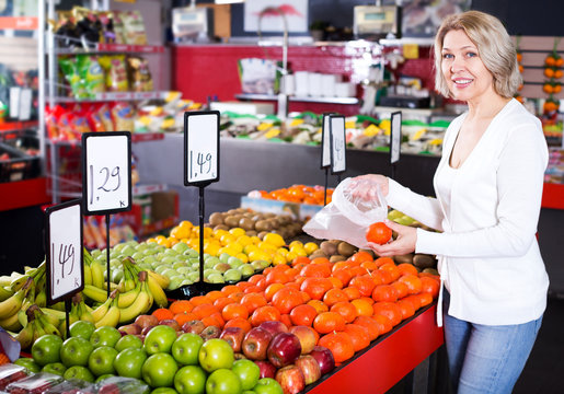 Female pensioner buying fresh fruits
