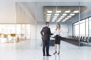 Business partners shaking hands in lobby