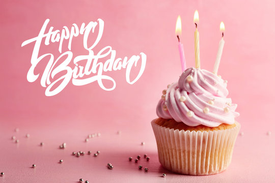 Birthday cupcake  with candle on pink background