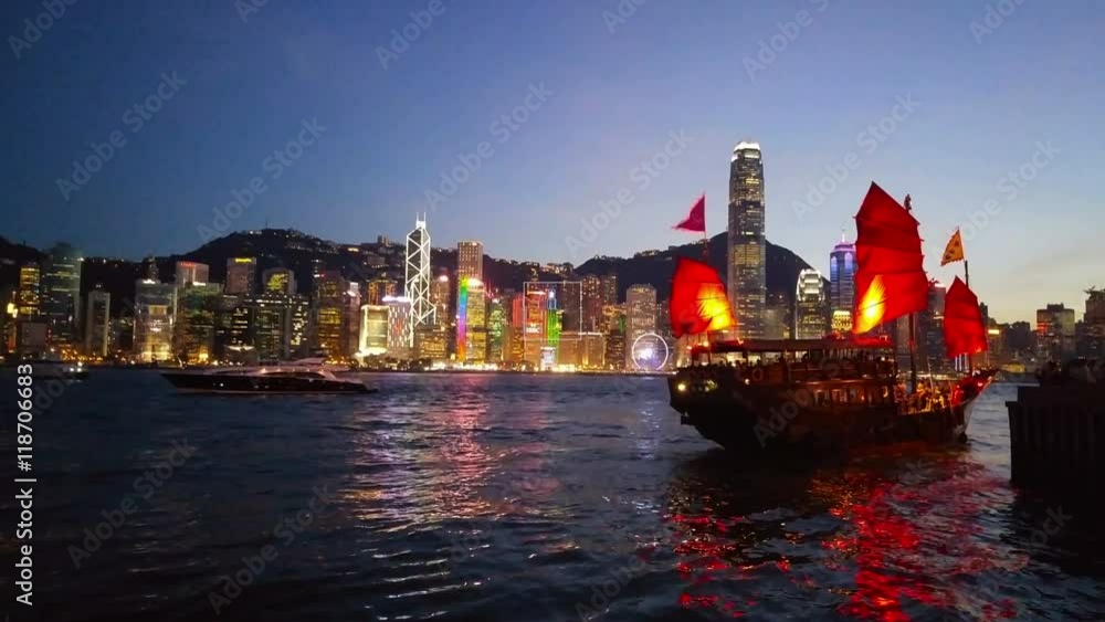 Poster Skyline of Hong Kong at night. Beautiful skyscrapers with red boat at Kowloon bay