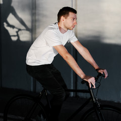 Fototapeta na wymiar Young man rides stylish bicycle