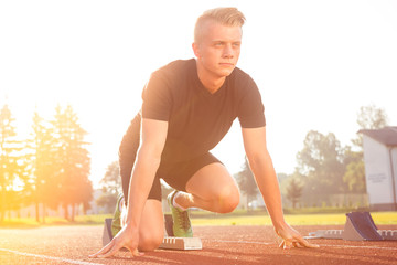Athletic man starting jogging in sun rays
