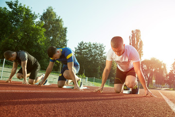 Athletic man starting jogging in sun rays