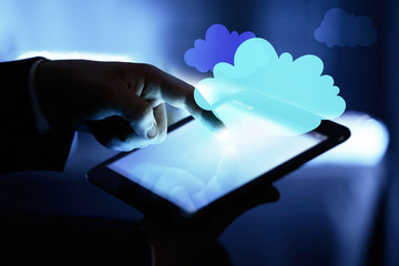 Businessman using tablet on blurred background. Cloud computing and information storage concept.