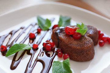 Delicious fondant with red currant on plate, closeup