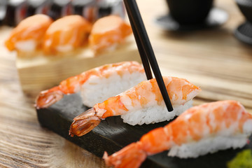 Tasty sushi with black chopsticks, closeup